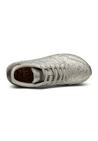Glittrig silver sneakers med en strukturerad yta, ljusgrå snören och en vadderad korksula. Rund tå och en flexibel sula.