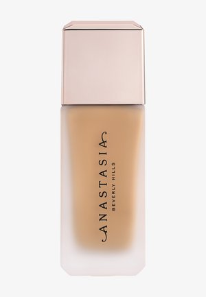 Mattierte Glasflasche der flüssigen Foundation von Anastasia Beverly Hills mit beiger Kappe und Logo auf weißem Hintergrund.