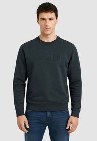 Felpa verde scuro con polsini e orlo a coste, con logo "GAUDÌ" in rilievo sul davanti. Tessuto morbido, design classico con scollo tondo.