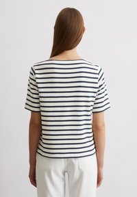 Gestreiftes Baumwoll-T-Shirt mit rundem Ausschnitt und kurzen Ärmeln, in Marineblau und Weiß mit horizontalen Streifen, von hinten betrachtet.