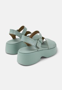 Mint green platform sandals with a smooth leather upper, adjustable buckle strap, and a cushioned footbed. Features a thick, textured sole.