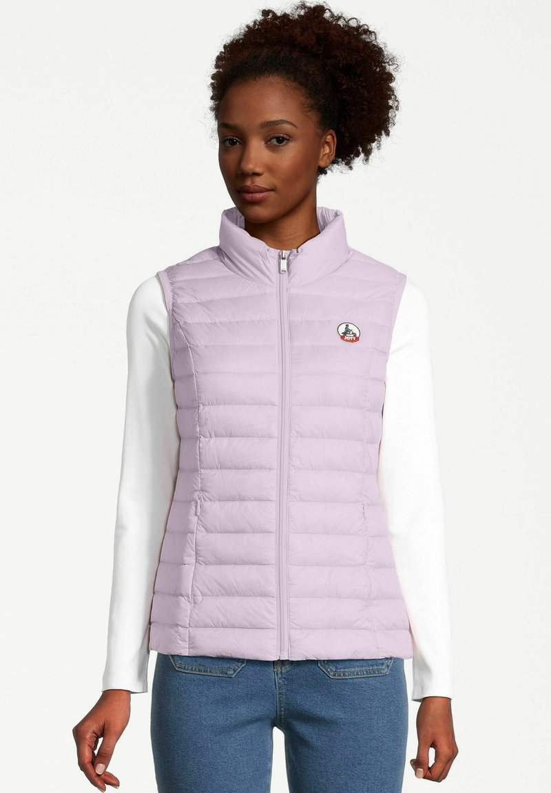 Chaleco acolchado de color púrpura claro con cuello alto, cierre de cremallera y costuras horizontales. Presenta un pequeño logo en el pecho. Lleva puesto sobre una camiseta de manga larga blanca.