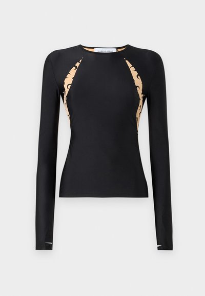 Maglietta nera a maniche lunghe con un design aderente, caratterizzata da pannelli laterali crema con un motivo scuro, colletto tondo e texture affusolata.