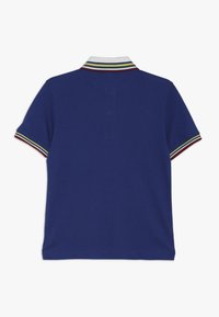 Marinblå polo-shirt med en treknapps krage, med flerfärgade randiga detaljer på kragen och ärmarna. Slät tygstruktur.