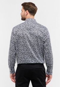 Langsleeve shirt met een zwart-wit abstract patroon, lichtgewicht stof, knoopmanchetten en een standaardkraag.