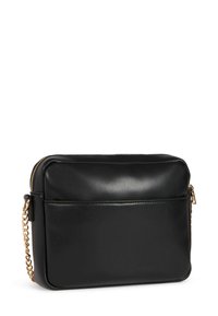 Borsa a tracolla nera in pelle con forma rettangolare, tracolla in catena dorata, chiusura con cerniera e tasca frontale. Texture morbida, design minimalista.