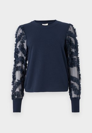 Sweatshirt bleu marine à manches longues avec des manches transparentes à volants. Tissu doux, poignets ajustés et embellissements floraux sur les manches. Encolure ronde.
