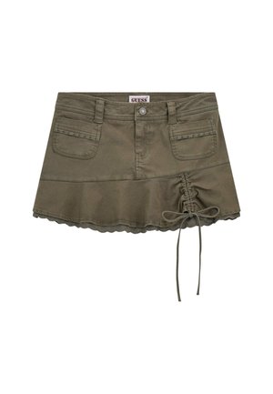 Jupe en coton vert olive présente un design évasé, un ourlet festonné, deux poches avant et un détail à cordon sur un côté.