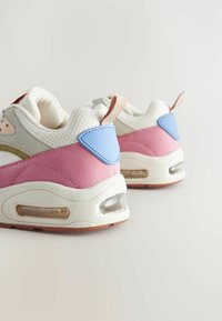 Baskets roses et blanches avec une tige en mesh, semelle rembourrée, poche à air transparente et accents en bleu et gris contrastants. Semelle extérieure en caoutchouc.