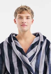 Accappatoio a righe in morbido e soffice materiale; presenta strisce blu navy scure e grigie chiare, colletto a scialle e una vestibilità comoda.