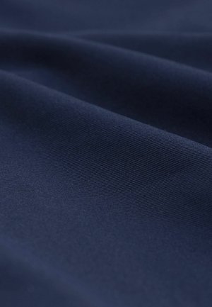 Tessuto blu navy con una trama liscia, caratterizzato da sottili motivi a tessitura diagonale e un morbido drappeggio, ideale per abbigliamento o rivestimenti.