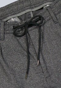 Graue gewebte Hosen aus einem strukturierten Gewebe, mit einem elastischen Bund und einem schwarzen Zugband sowie goldfarbenen Akzenten an den Enden.