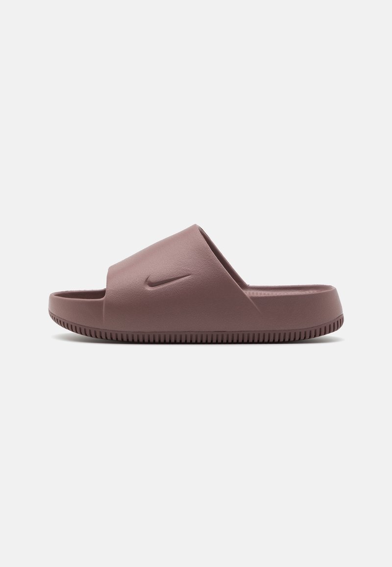 Sandale slide Nike marron avec une bride épaisse sur le pied et une semelle texturée, vue de côté sur un fond uni.