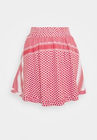 Jupe à motifs rouge et blanc avec une taille froncée et une silhouette évasée et ample sur un fond blanc uni.