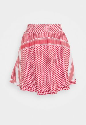 Jupe à motifs rouge et blanc avec une taille froncée et une silhouette évasée et ample sur un fond blanc uni.