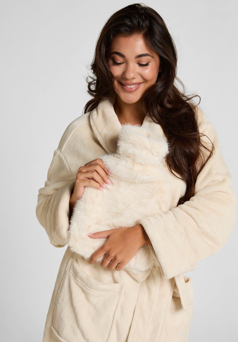 Crème-kleurige pluche ochtendjas met sjawl kraag. Zachte, gestructureerde stof. Inclusief zakken. Houdt een bijpassende zachte, donzige warmtepack vast.