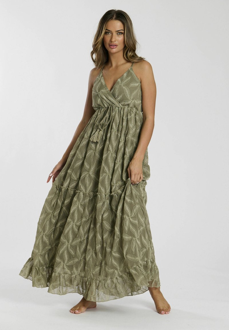 Robe maxi en vert olive avec un motif de feuilles. Caractéristiques : bretelles réglables, corsage froncé et ourlet en volants superposés. Tissu léger.
