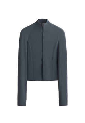 Grå zip-up jacka med långa ärmar, ribbad textur och släta paneler. Har hög krage och figurnära design med sidofickor.