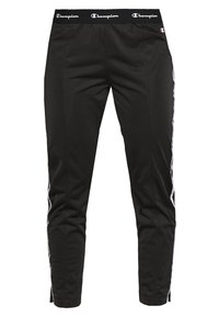 Svarta träningsbyxor med elastisk midja, vita sidostråkar, framfickor och design med smalnade ben. Tillverkade av mjukt, lätt material.