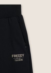 Pantaloni jogger neri in cotone misto, dotati di vita a coste, pannelli laterali texturizzati e logo stampato "FREDDY ATHL DEPT TRAINING".