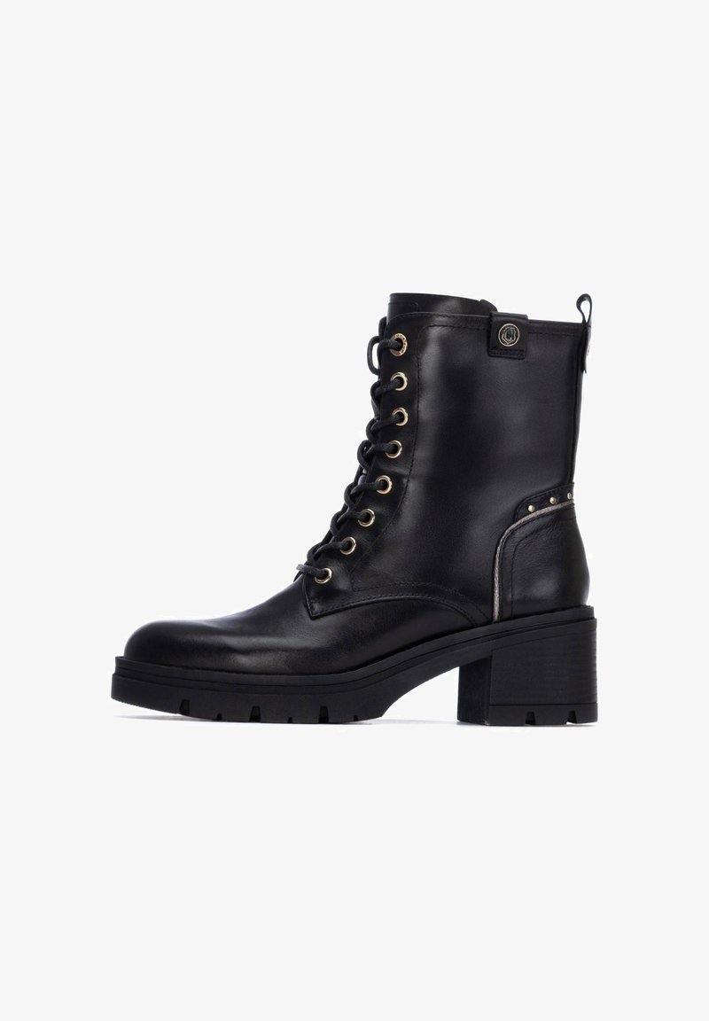 Stivaletti in pelle nera con tacco spesso, lacci sul fronte, occhietti dorati e borchie decorative sui lati. Texture liscia, design robusto.