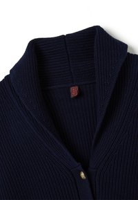 Marineblauer gerippter Pullover mit einem breiten Schalkragen, ausgestattet mit einem goldenen Knopfverschluss und einem roten gewebten Etikett am Hals. Strukturierte Stoffqualität.