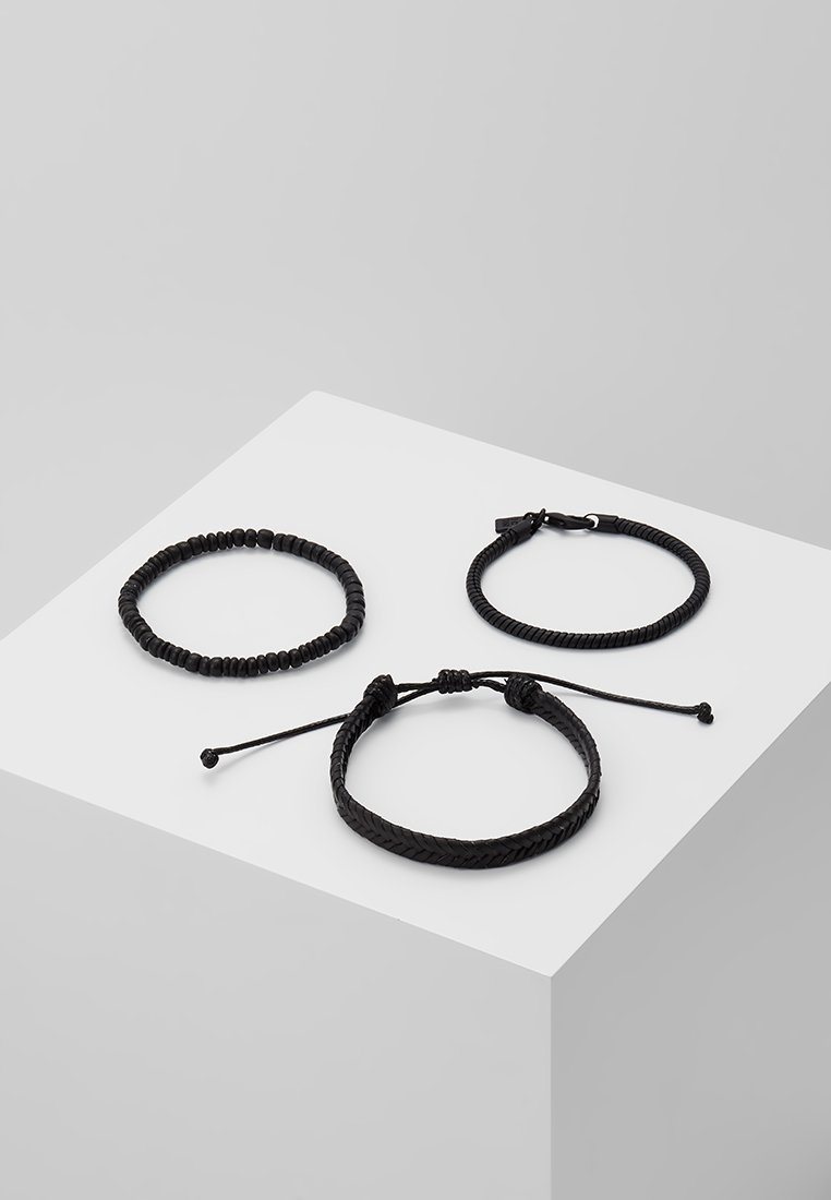 Tre svarte armbånd: ett elastisk perlearmbånd, ett lærvevd med lås, og ett enkelt flettet med justerbar knute.