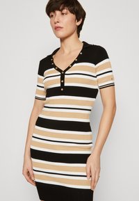 Abito aderente a costine con scollatura a V e maniche corte, caratterizzato da strisce orizzontali in nero, beige e bianco, con dettagli in bottone dorato.
