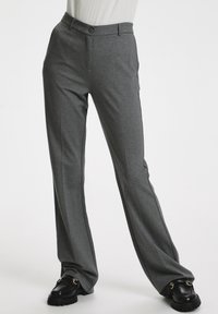 Pantaloni grigi su misura con taglio slim, realizzati in un tessuto morbido. Presentano tasche frontali, chiusura con bottone e righe laterali a contrasto.