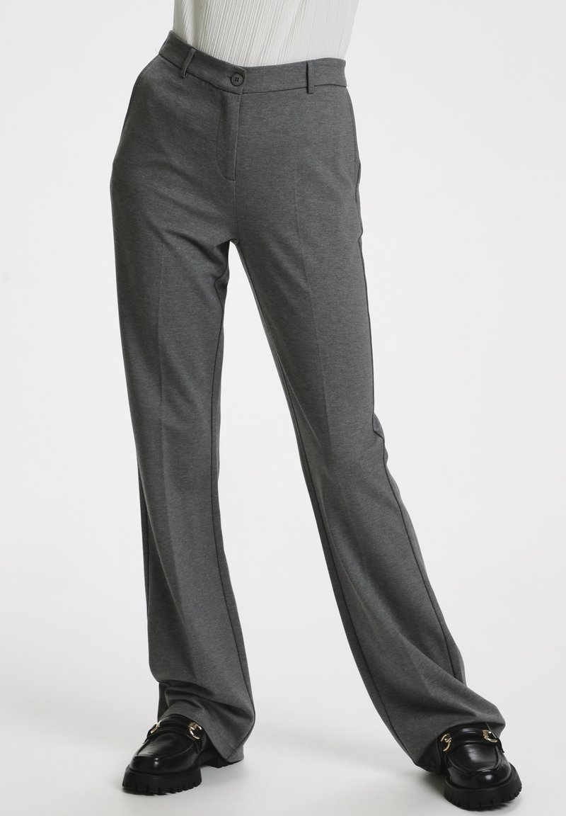 Pantaloni grigi su misura con taglio slim, realizzati in un tessuto morbido. Presentano tasche frontali, chiusura con bottone e righe laterali a contrasto.