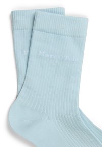 Calzini azzurri chiaro a coste con una texture morbida, caratterizzati da un logo sottile in bianco. Realizzati con un materiale elasticizzato per il massimo comfort.