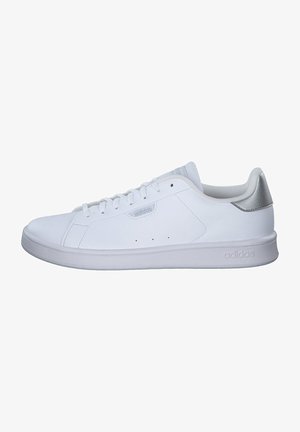 White athletic shoe with a smooth leather upper, lace-up design, and minimalistic style. Features a grey heel accent and textured sole.