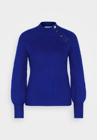 Pull bleu en tricot avec col montant ; manches raglan et trois boutons décoratifs sur l'épaule. Tissu texturé.