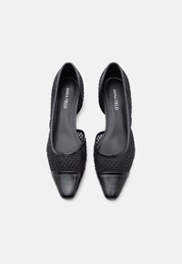 Μαύρες flat παπούτσια με尖尖 μύτη, υφασμάτινο επάνω μέρος με υφή, λείο δέρμα στην άκρη της μύτης και το όνομα της μάρκας ανάγλυφο στο εσωτερικό. Διαθέτουν χαμηλή κοπή.