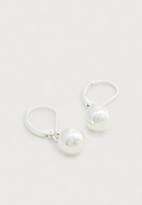 Orecchini pendenti con perle bianche e montatura in tono argento; perle rotonde con finitura lucida; chiusura a leva per una vestibilità sicura.