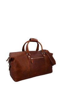 Ruskea nahkainen duffel-laukku, jossa kaksi yläkahvaa ja irrotettava hihna. Edessä vetoketjutasku ja sileä, teksturoitu pinta.