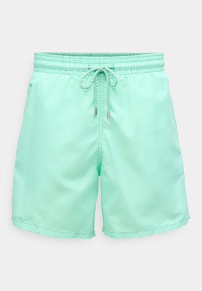 Mėtiniai žali maudymosi šortai, pagaminti iš lengvos, glotnios medžiagos. Turi elastinę juosmenį su raišteliu ir šonines kišenes.