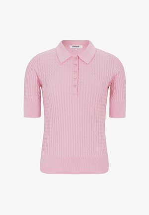 Īsroku polo krekls maigi rozā krāsā ar teksturētu adījuma rakstu, trīs pogu aizdari un ribveida apkakli un apakšu. Izstrādāts piegulošam siluetam.