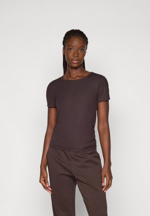 Donkerbruin geribbelde t-shirt met korte mouwen en een ronde halslijn, aansluitende snit en subtiele zijruche, gecombineerd met bijpassende joggingbroek.