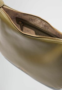Olivengroene leren clutch met rits, voorzien van een lichtgeklede voering en een interne zak met reliëf logo patroon.