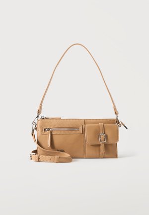 Sac à main en cuir marron clair avec deux poches avant, une avec une fermeture éclair et une avec une boucle, et une bandoulière amovible.