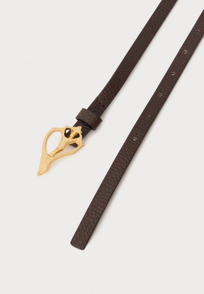 Ceinture en cuir brun foncé texturé avec une boucle dorée unique en forme de crâne animal abstrait, présentée sur un fond uni.