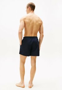 Marineblaue Schwimmshorts mit elastischem Bund, einer einzigen Gesäßtasche und einer lockeren Passform, hergestellt aus leichtem Stoff.