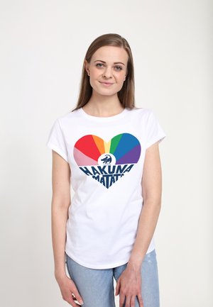 T-shirt en coton blanc avec un design de cœur aux couleurs de l'arc-en-ciel et "HAKUNA MATATA" en texte navy en gras. Manches courtes, coupe décontractée.