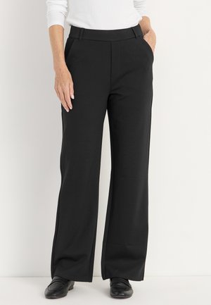 Zwarte wijde broek met een gladde textuur, voorzien van zakken en een op maat gemaakte tailleband, gecombineerd met zwarte schoenen.