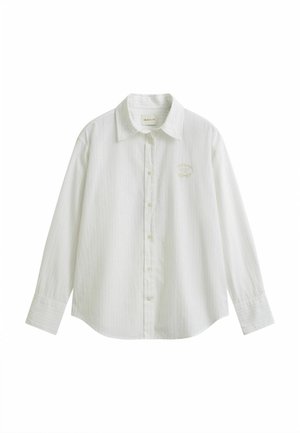 Chemise blanche à manches longues avec col, rayures verticales discrètes et petit logo brodé sur le côté gauche de la poitrine.