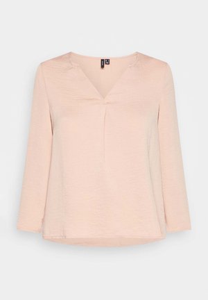 Blusa rosa chiaro a maniche lunghe con scollo a V e tessuto morbido e strutturato su uno sfondo chiaro uniforme.