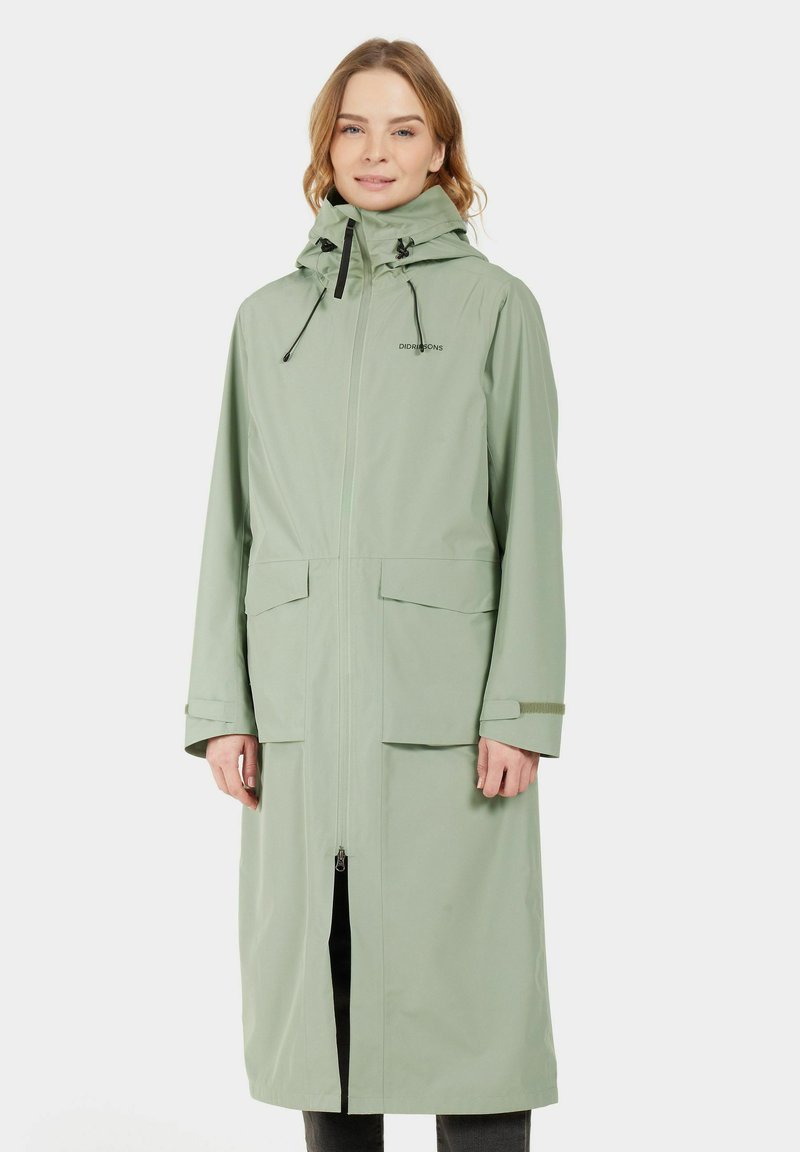 Impermeable largo de color verde claro hecho de material resistente al agua, con capucha, cremallera frontal, dos bolsillos delanteros y puños ajustables.