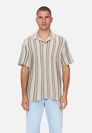 Kortærmet skjorte i cremefarve med brune lodrette striber, knaplukning fortil, afslappet pasform, struktureret stof, kombineret med lyseblå denimjeans.
