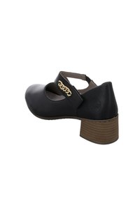 Chaussure en cuir noir avec un talon empilé de hauteur moyenne, une bride réglable et un accent de chaîne en or. Elle présente un bout arrondi et une texture lisse.